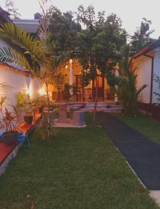 a house with a yard with trees and plants at Villa 96 in Unawatuna