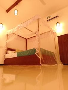 a bedroom with a bed with a mosquito net at Villa 96 in Unawatuna