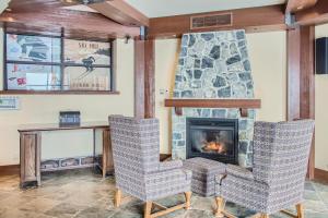 a living room with two chairs and a fireplace at Stonegate Resort Unit C202 in Big White