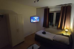 a bedroom with a bed and a tv on the wall at Hehlentor-City Gäste Wohnung in Celle +1 photo