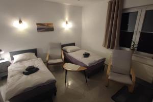 a room with two beds and a table and chairs at Hehlentor-City Gäste Wohnung in Celle