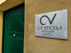 a sign on the side of a building with a door at Ca' Vittoria Urban Lodge in Alba