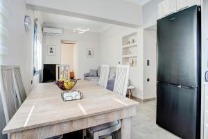 a kitchen with a wooden table and a black refrigerator at Kate's house MJT in Mytilene
