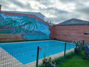 a mural on the side of a building with a swimming pool at Casa de pueblo in Babilafuente