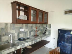 a kitchen counter with a sink and a cabinet at Villa 96 in Unawatuna