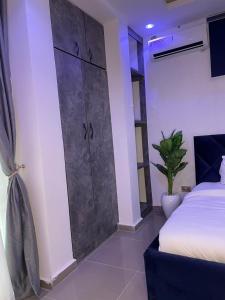 a bedroom with a bed and a large sliding door at Wine House, Maitama, Abuja in Abuja