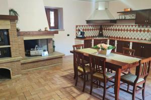 a kitchen with a wooden table and a fireplace at Colibrì - Villa di Charme in Ferentino +19 photos