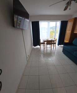 a living room with a table and a blue couch at Olivier in Le Lavandou