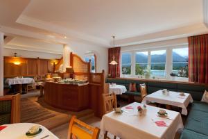 a restaurant with tables and chairs and windows at Hotel Garni Buchinger in St. Wolfgang