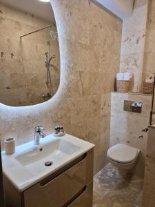 a bathroom with a sink and a toilet and a mirror at Apartamente Vista Lago e Mare in Eforie Nord +22 photos