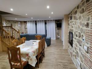 a dining room with a table and a stone wall at Casa vacacional Los Enserados in Renedo de Piélagos
