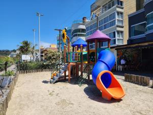 einen Spielplatz mit Rutsche im Sand in der Unterkunft Acrópole Residence in Bombinhas