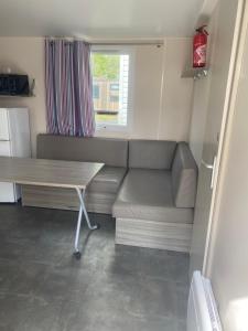a living room with a couch and a table at Mobil home en Vendée in Angles