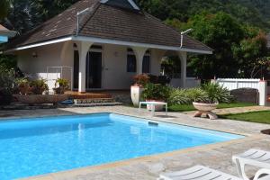 a swimming pool in front of a house at Pension de famille HITI MOANA VILLA in Papara +37 photos