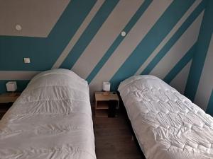 two beds in a room with blue and white stripes at Laetoile in Granges-sur-Vologne