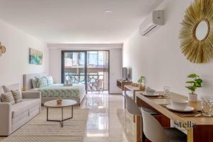 una sala de estar con un sofá y una mesa en Chic Studio at My Menesse In Playa with Roof Pool, en Playa del Carmen