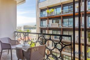 Un balcón con sillas y una mesa en un edificio. en Chic Studio at My Menesse In Playa with Roof Pool, en Playa del Carmen