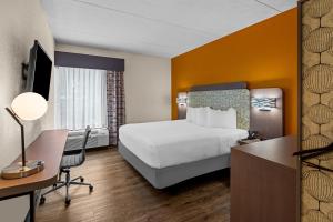 a hotel room with a bed and a desk with a computer at Spark by Hilton Syracuse Carrier Circle in East Syracuse