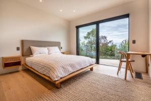 a bedroom with a bed and a large window at Sky High Retreat in Nelson