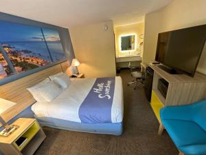 a hotel room with a bed and a flat screen tv at Days Inn by Wyndham Renfro Valley Mount Vernon in Mount Vernon