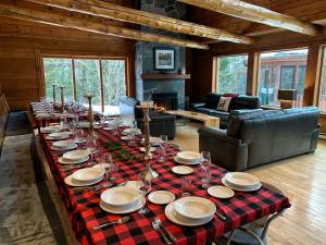 a long table with plates and wine glasses on it at Howard Lodge & Spa in Saint Adolphe D'Howard +46 photos