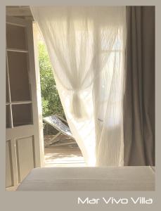 une porte ouverte avec un rideau blanc dans une pièce dans l'établissement MarVivo Villa - Rez de Jardin - Plage 3' à pied, à La Seyne-sur-Mer