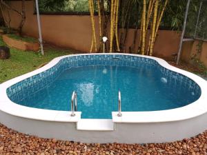 a bath tub with a pool of water in a yard at Cocoon Earth Home - Pool Villa Kovalam in Kovalam