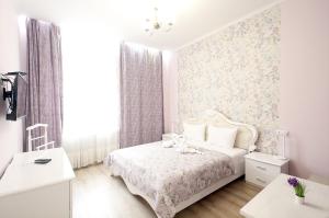 リヴィウにある"Deluxe Apartments" U 5 - 12218の花柄の壁紙が貼られたベッドのある寝室