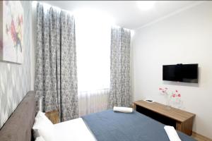 リヴィウにある"Deluxe Apartments" U 5 - 12218のベッドとテレビと窓のある寝室