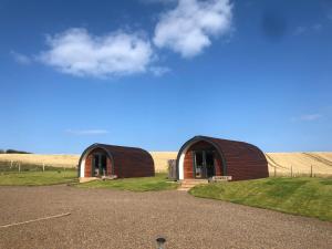 a small building in the middle of a field at Milldown Glamping in Coldingham