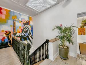 a staircase with a painting of a man playing a saxophone at Classy and Newly Renovated Studio in Observatory in Cape Town
