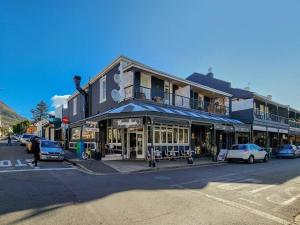 a building on a street with cars parked in front of it at Classy and Newly Renovated Studio in Observatory in Cape Town