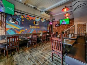 a restaurant with tables and chairs and a wall with a mural at Classy and Newly Renovated Studio in Observatory in Cape Town