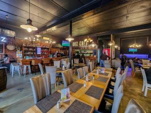 a restaurant with wooden tables and chairs and a bar at Classy and Newly Renovated Studio in Observatory in Cape Town