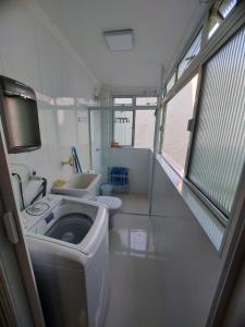 um pequeno banheiro com um vaso sanitário e uma pia em Apartamento Estúdio em Caraguatatuba com Garagem em Caraguatatuba mais 17 fotografias