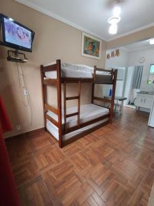 Zimmer mit 2 Etagenbetten und einem Flachbild-TV in der Unterkunft Apto no Centro de Bertioga, próx a Praia da Enseada e da Balsa com acesso a Prainha Branca, Acomoda até 6 pessoas in Bertioga