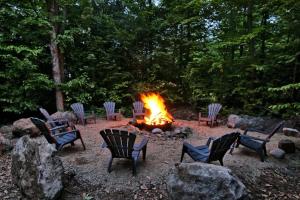 a group of chairs around a fire pit at Blue Hill Pool spa game room mountain view in Morin Heights +28 photos