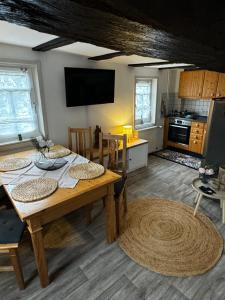 a dining room with a table and a kitchen at Landhaus an der Ottoburg in Schlitz