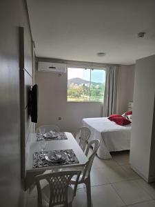 um quarto com uma mesa, cadeiras e uma cama em Residencial Flórida I em Bombinhas