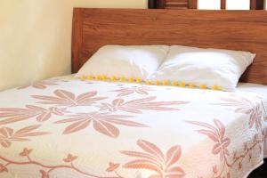 Cama con cabecero marrón con estampado de flores en Mandala Bungalows, en Ubud