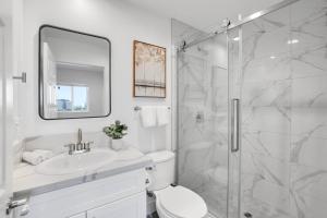 a white bathroom with a shower and a sink at Luxe Townhouse Near Downtown La in Los Angeles +31 photos
