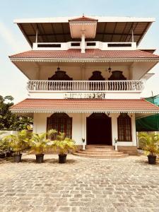 a white building with a balcony and some plants at Cleety's Residency in Cochin