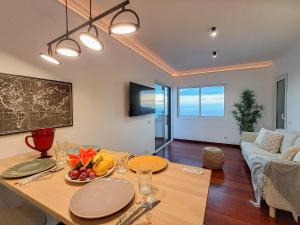 a living room with a table and a couch at Funchal Sunset Apartment in Funchal
