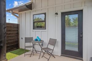 eine Terrasse mit Stühlen und einem Tisch vor einem Haus in der Unterkunft Eagle's Villa - Hot Tub 5 Min to Main in Fredericksburg