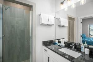 ein Badezimmer mit Dusche, Waschbecken und Spiegel in der Unterkunft Eagle's Villa - Hot Tub 5 Min to Main in Fredericksburg