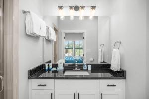 ein Badezimmer mit Waschbecken und großem Spiegel in der Unterkunft Eagle's Villa - Hot Tub 5 Min to Main in Fredericksburg + 11 Fotos