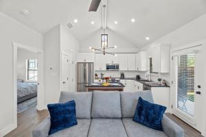 un salon avec un canapé et une cuisine dans l'établissement Eagle's Hub - Hot Tub 5 Min to Main, à Fredericksburg