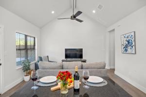 - un salon avec un canapé et une table avec des verres à vin dans l'établissement Eagle's Hub - Hot Tub 5 Min to Main, à Fredericksburg