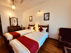 two beds in a hotel room with a mirror at Cleety's Residency in Cochin +12 photos