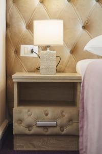 einen Nachttisch mit einer Lampe neben einem Bett in der Unterkunft Hotel Stella Maris - Style & Comfort in Vodice